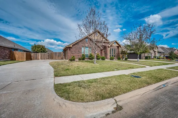 a view of a big house with a big yard and potted plants