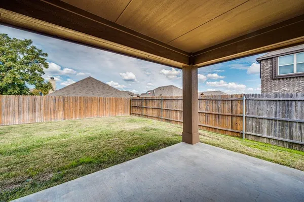 a view of backyard with wooden fence