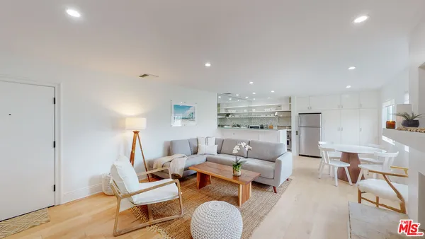 a living room with furniture and a view of kitchen