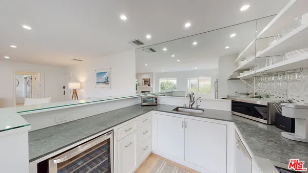 a kitchen with granite countertop a sink stainless steel appliances and cabinets