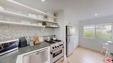 a kitchen with stainless steel appliances white cabinets and a stove top oven