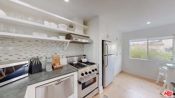 a kitchen with stainless steel appliances white cabinets and a stove top oven