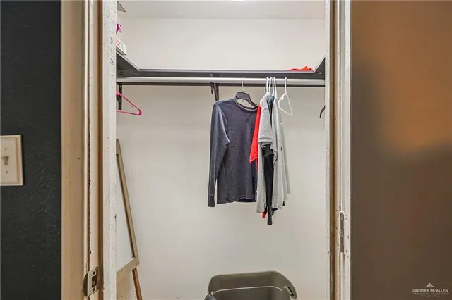 a view of walk in closet with clothes