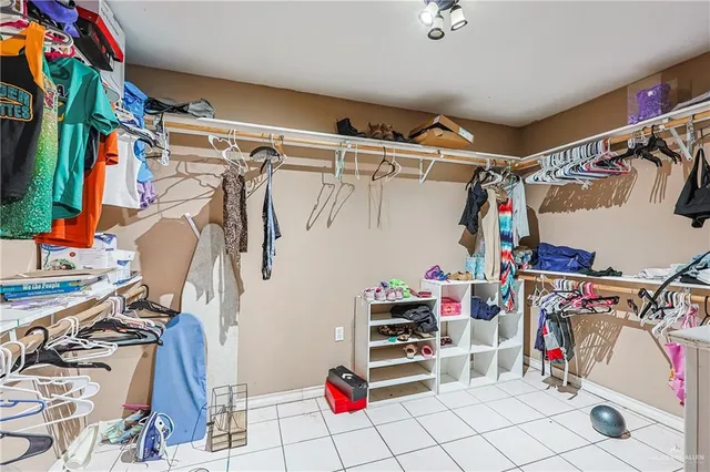 a view of walk in closet with clothes and shoes