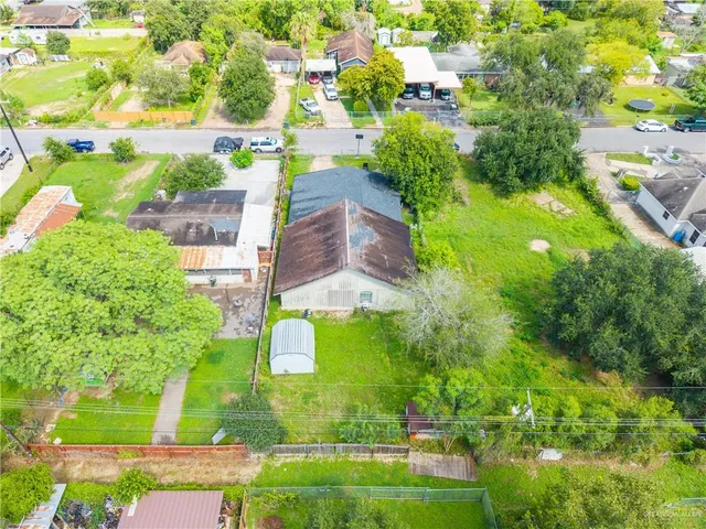 a aerial view of a house with a yard and large trees