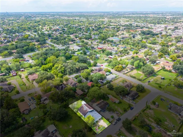 an aerial view of residential houses with outdoor space and trees