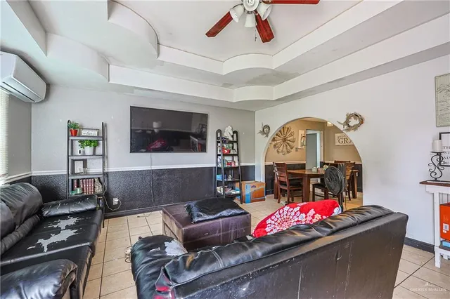 a living room with furniture a window and a flat screen tv
