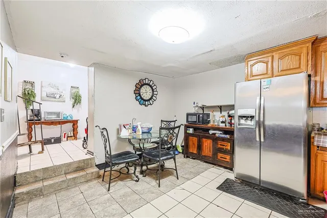 a outdoor kitchen with a refrigerator a stove top oven and a dining table