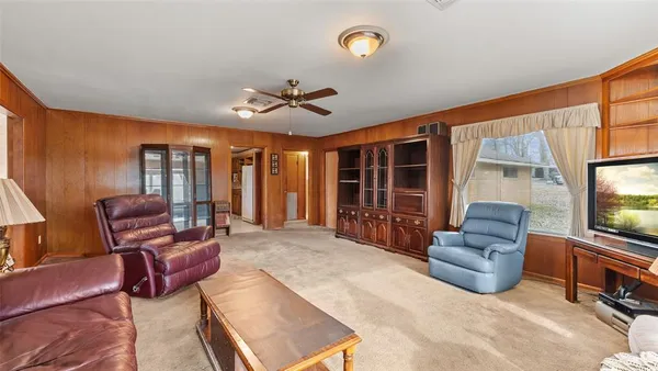 a kitchen with stainless steel appliances granite countertop a refrigerator a sink dishwasher a dining table and chairs with wooden floor