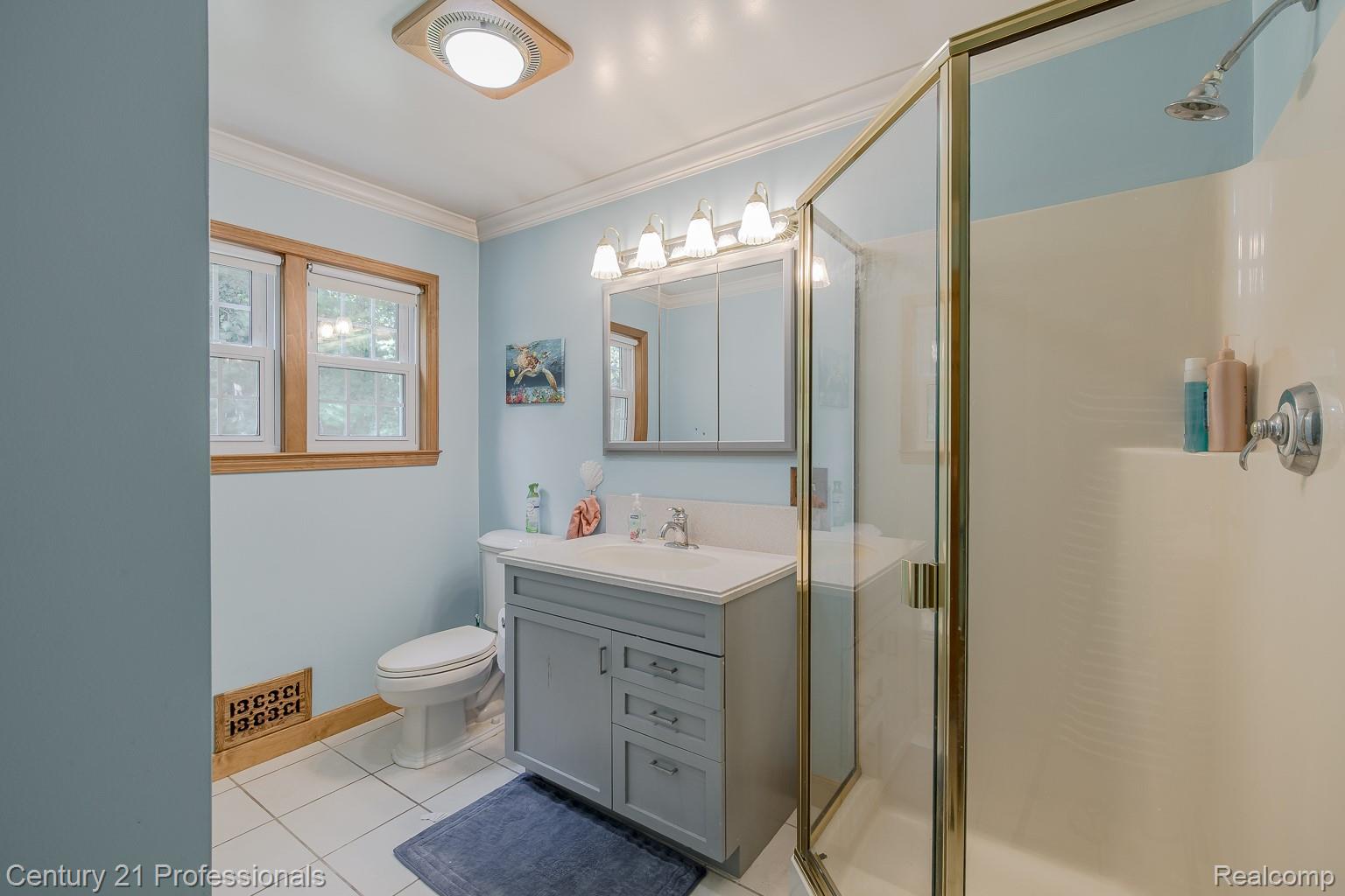 1790 Kent Road Ortonville, MI 48462 - Photo 19 of 64 Bathroom featuring a single vanity with a white countertop, a mirrored medicine cabinet, and a glass-enclosed shower with a built-in shelf