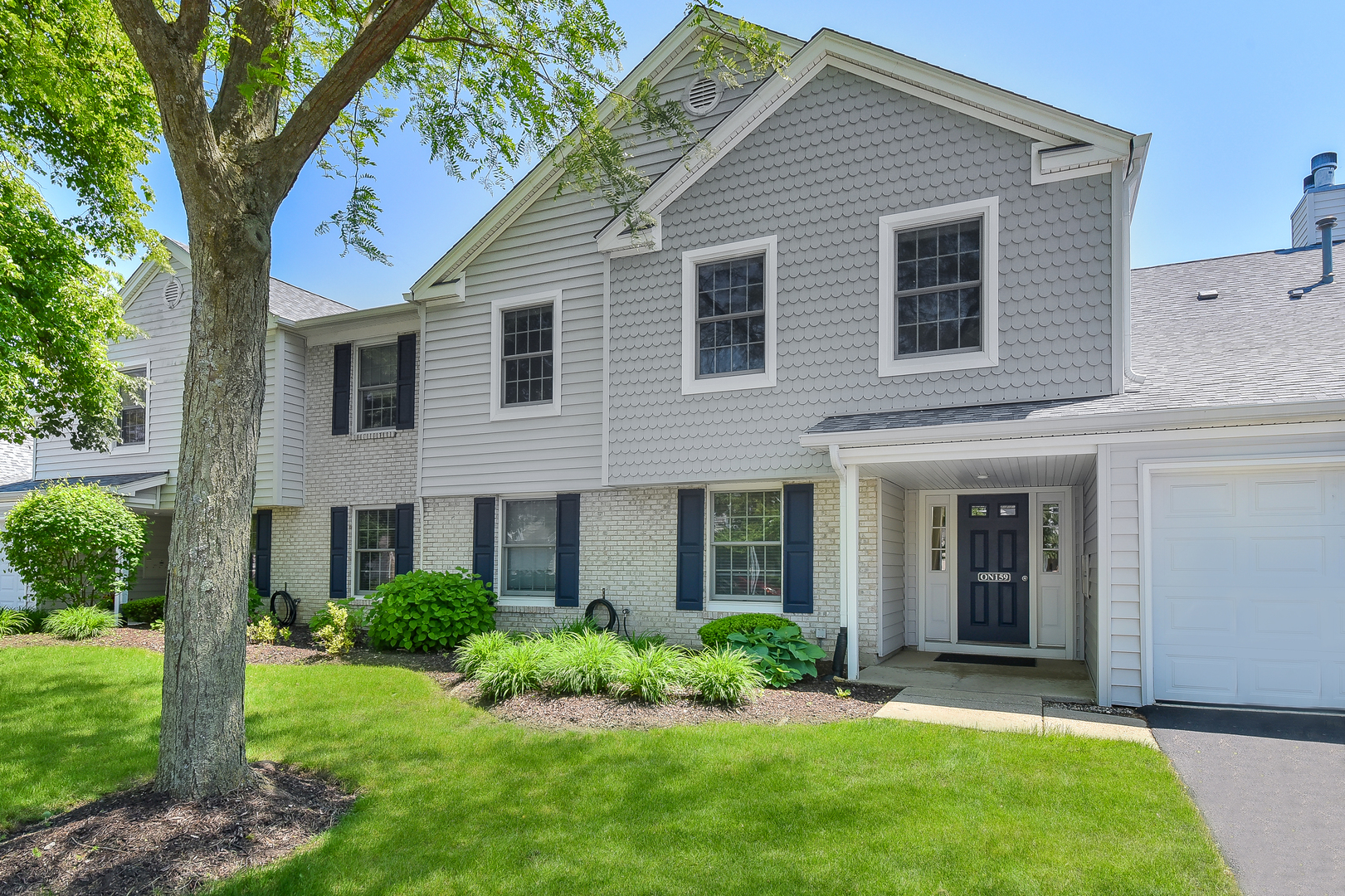 -n159 Windermere Road, Unit 1107 Winfield, IL 60190 - Photo 1 of 14 a view of a house with a yard and plants