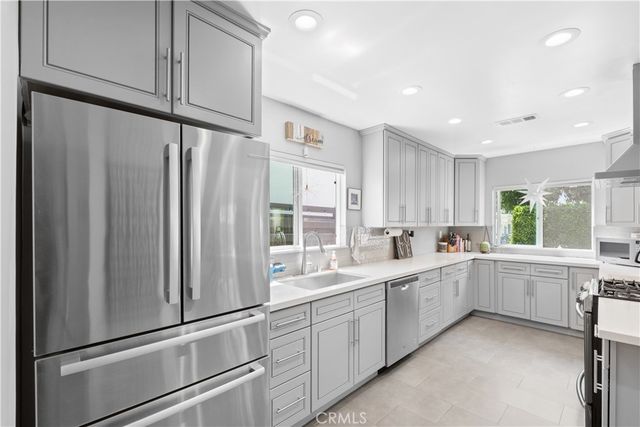 a kitchen with white cabinets and white appliances