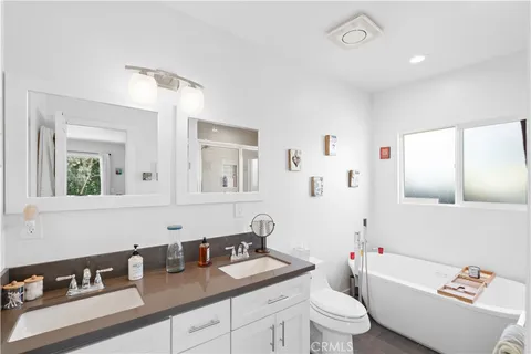 a bathroom with a granite countertop sink mirror vanity and toilet