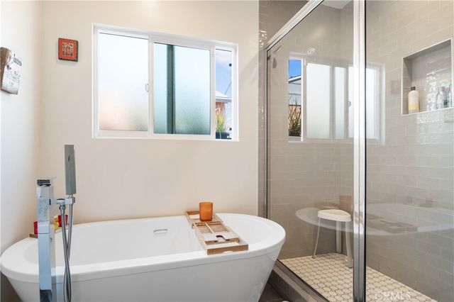 a white bath tub sitting next to a white toilet and a shower