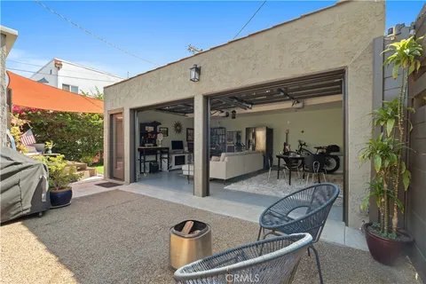 a view of a patio with table and chairs potted plants with wooden floor and seating space
