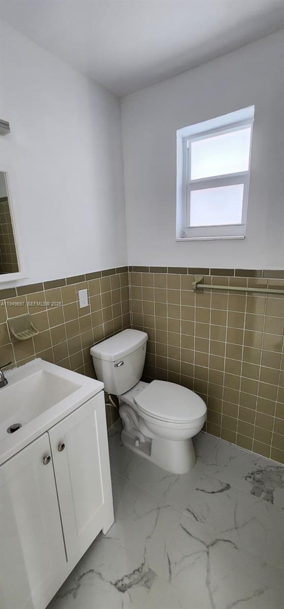 3520 Northwest 20th Street, Unit 2 Miami, FL 33142 - Photo 5 of 10 a bathroom with a sink a toilet and a mirror