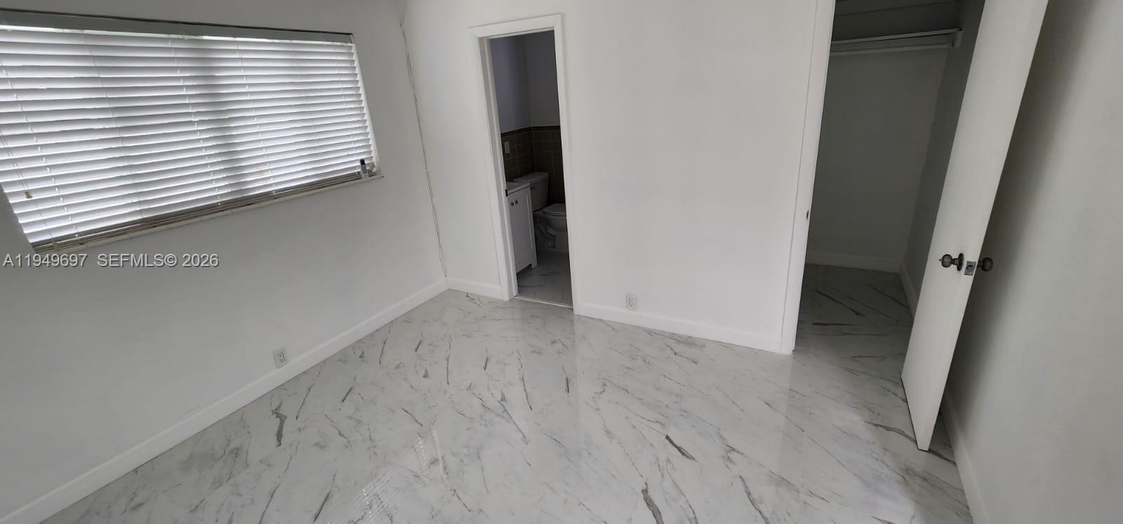 3520 Northwest 20th Street, Unit 2 Miami, FL 33142 - Photo 7 of 10 an empty room with wooden floor and a window