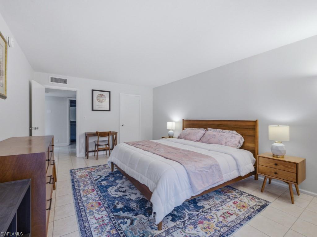 3 Bluebill Avenue, Unit 206 Naples, FL 34108 - Photo 9 of 19 a bedroom with a bed and a table in it