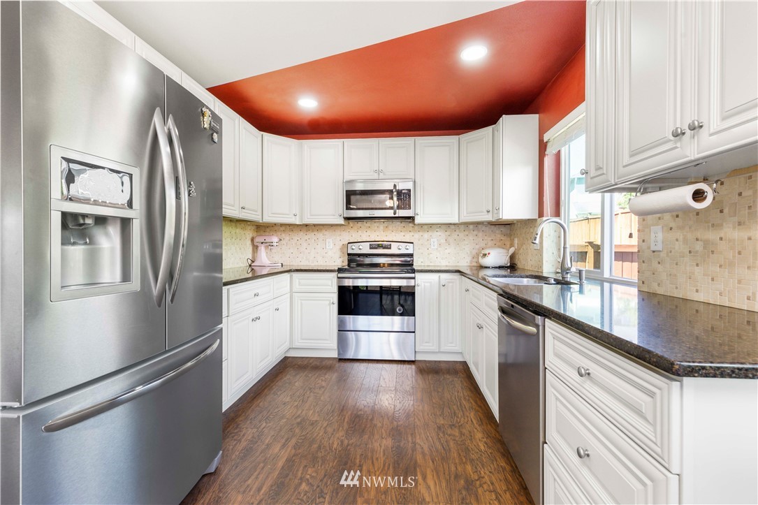 332 Index Avenue Southeast Renton, WA 98056 - Photo 11 of 23 a kitchen with granite countertop a refrigerator and a stove top oven