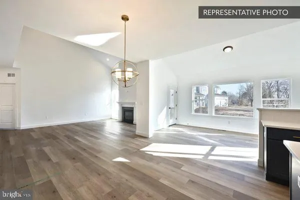 a view of a room with wooden floor staircase and a kitchen