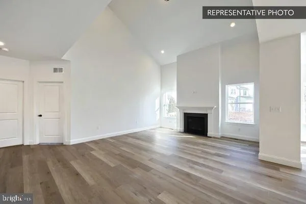 a view of empty room with wooden floor and fireplace