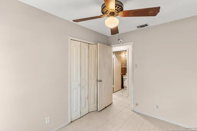 an empty room with a ceiling fan and a window