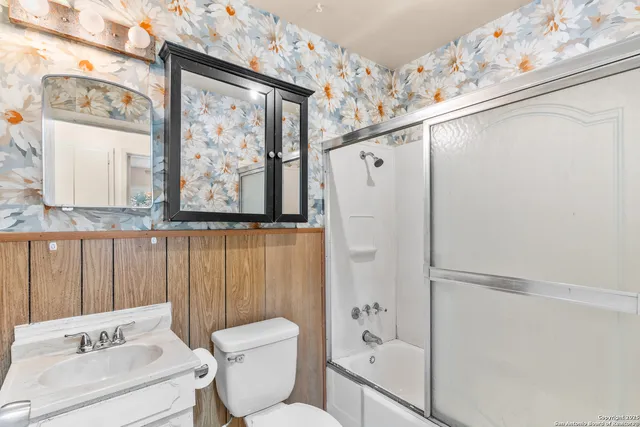 a bathroom with a shower toilet and sink