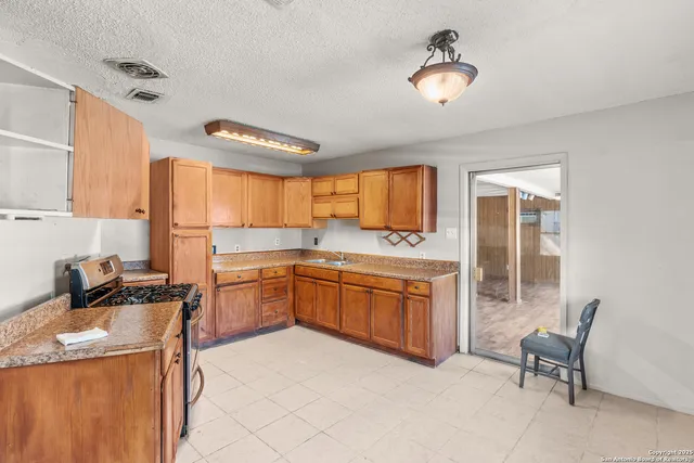 a kitchen with stainless steel appliances granite countertop a stove a sink and a refrigerator