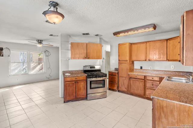 a kitchen with stainless steel appliances granite countertop a stove sink and cabinets