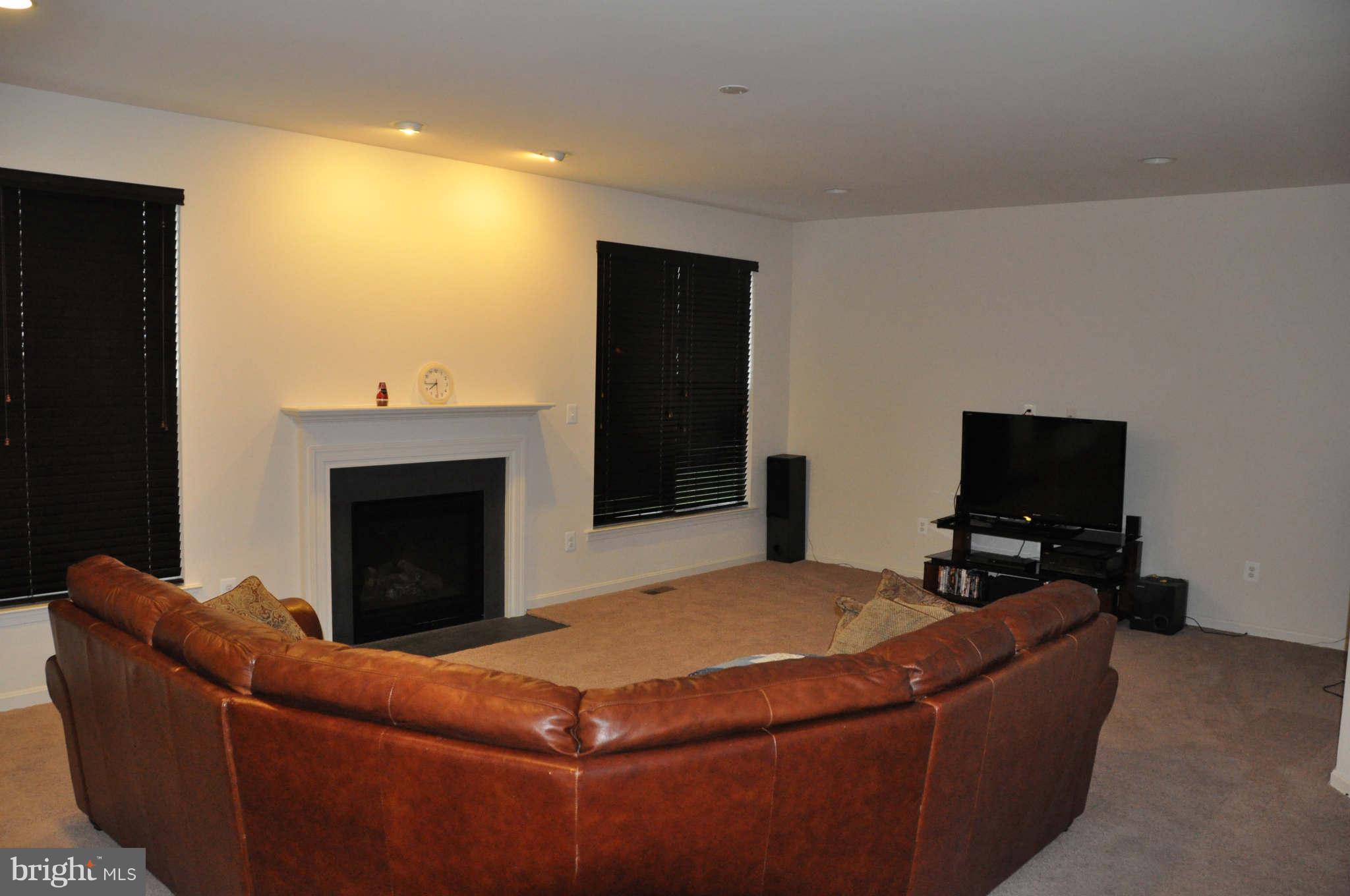 6627 Pebble Brooke Road Baltimore, MD 21209 - Photo 2 of 12 a living room with furniture a flat screen tv and a fireplace