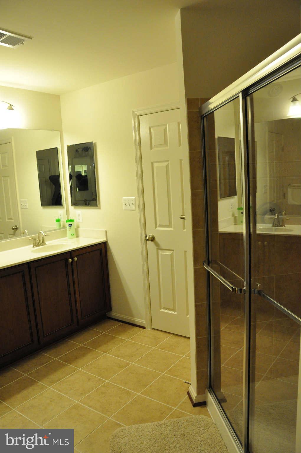 6627 Pebble Brooke Road Baltimore, MD 21209 - Photo 7 of 12 a bathroom with a double vanity sink a mirror and shower