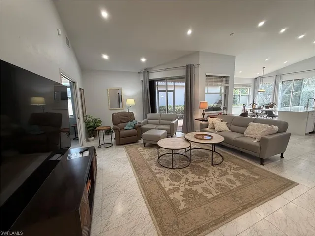 a living room with furniture a flat screen tv and large window
