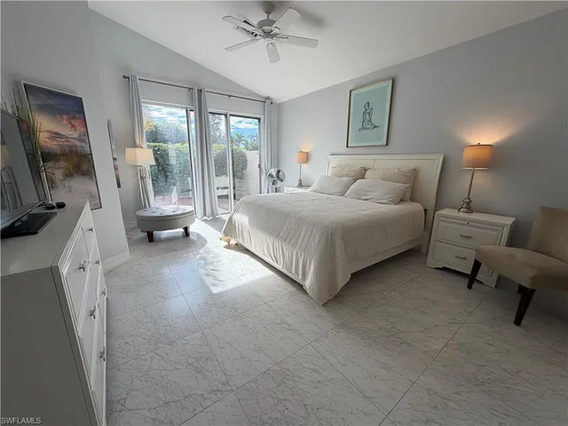 a spacious bedroom with a bed and a flat tv screen on dresser