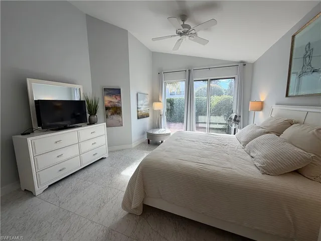 a bedroom with a large bed and flat tv