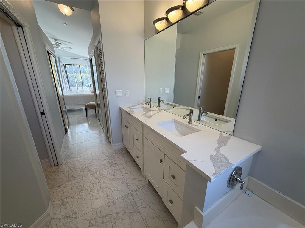 5950 Almaden Drive Naples, FL 34119 - Photo 29 of 41 a bathroom with a sink double vanity mirror and tub