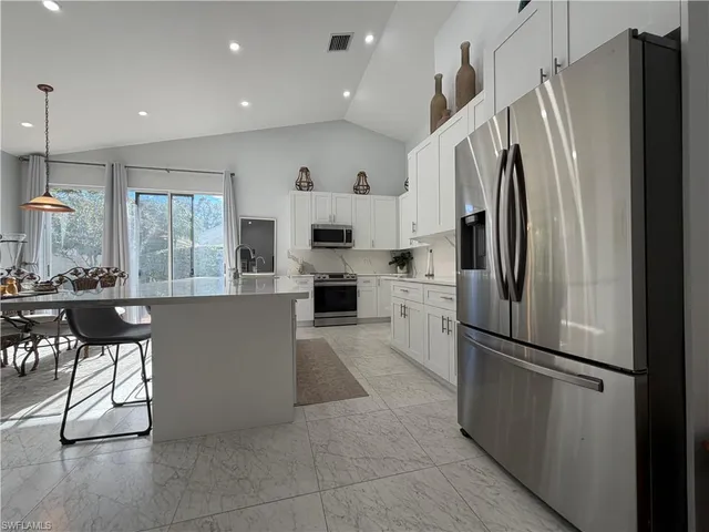 a kitchen with stainless steel appliances a refrigerator and a stove top oven