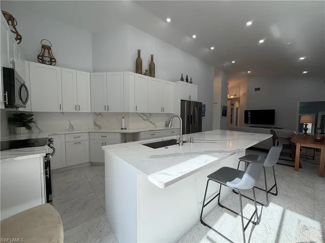 a kitchen with a sink white cabinets and stainless steel appliances