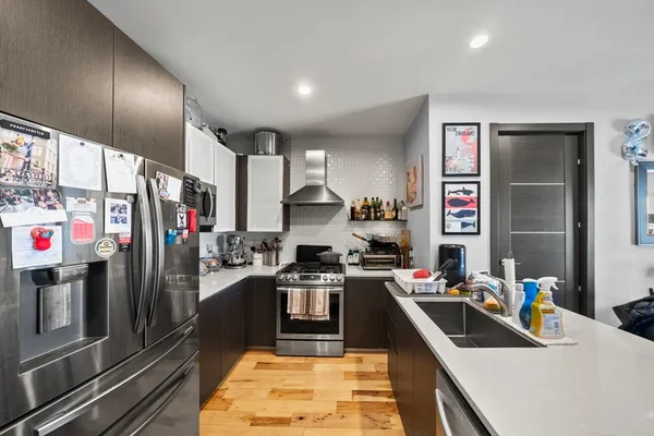 a kitchen that has a lot of cabinets a sink and appliances in it