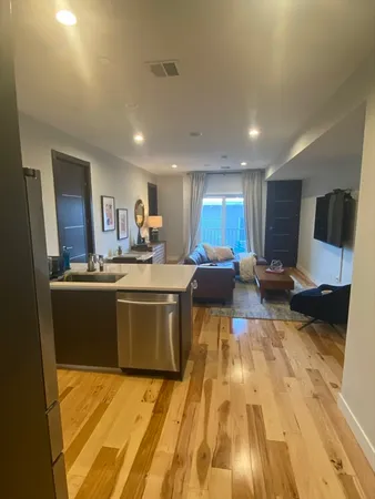 a large kitchen with stainless steel appliances a large counter top a stove and a refrigerator