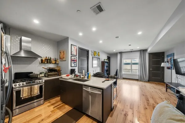 a kitchen that has a sink a stove and chairs
