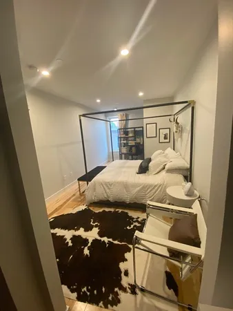 a bed sitting in a bedroom next to a window