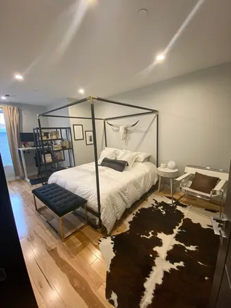 a bedroom with a bed and wooden floor