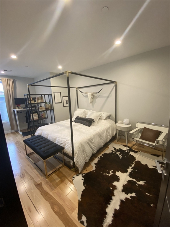 39 Lexington Street, Unit 5 Boston, MA 02128 - Photo 9 of 28 a bedroom with a bed and wooden floor