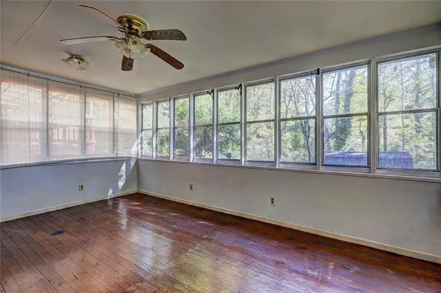 a view of room with window ceiling fan and hardwood floor