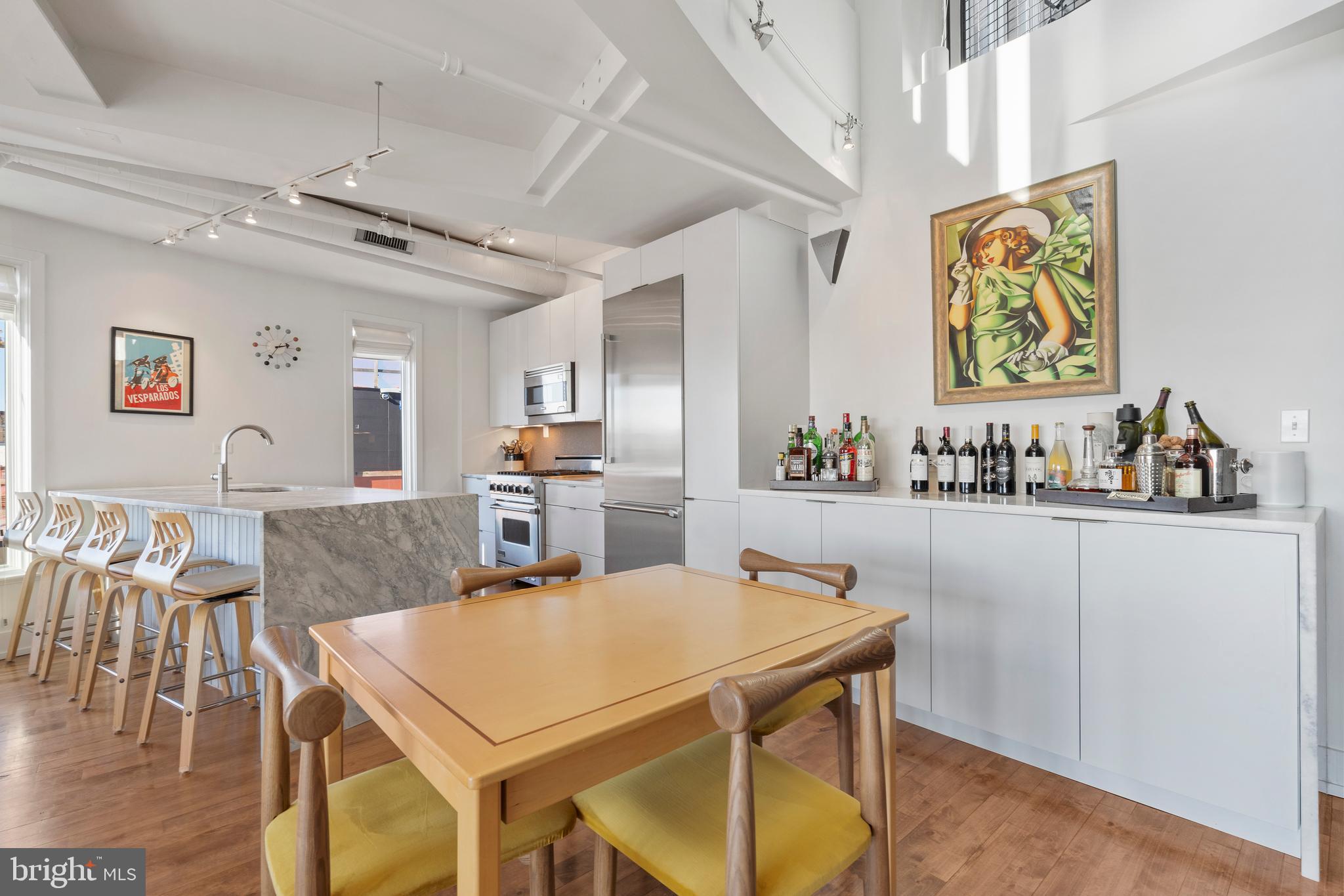1700 Kalorama Road Northwest, Unit PH502 Washington, DC 20009 - Photo 12 of 50 a kitchen with stainless steel appliances granite countertop a table chairs and a refrigerator