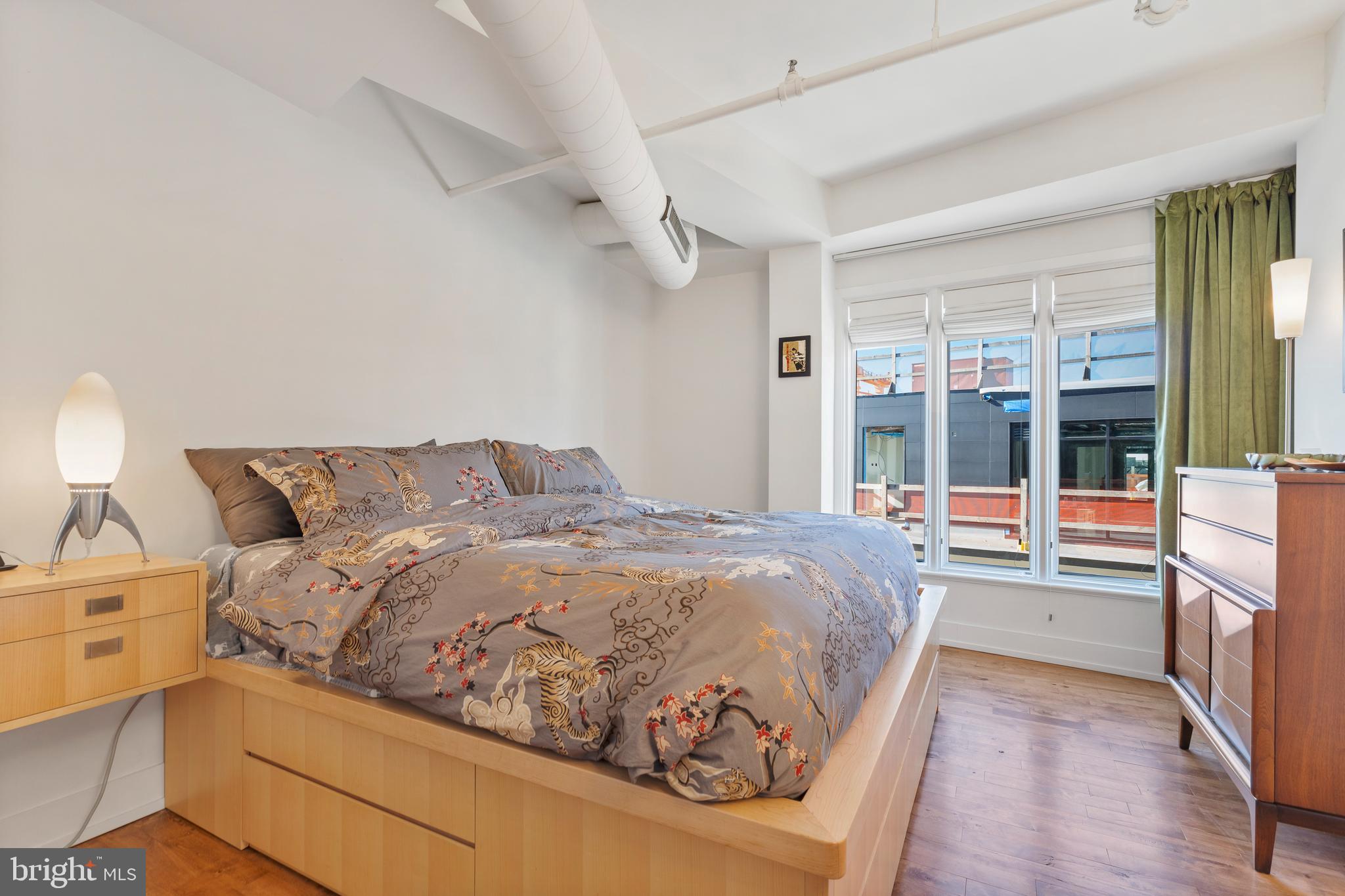 1700 Kalorama Road Northwest, Unit PH502 Washington, DC 20009 - Photo 13 of 50 a bed sitting in a bedroom next to a window