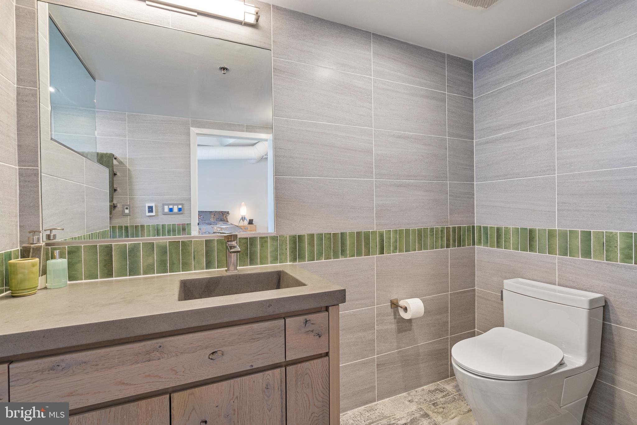 1700 Kalorama Road Northwest, Unit PH502 Washington, DC 20009 - Photo 16 of 50 a bathroom with a sink a toilet and a mirror