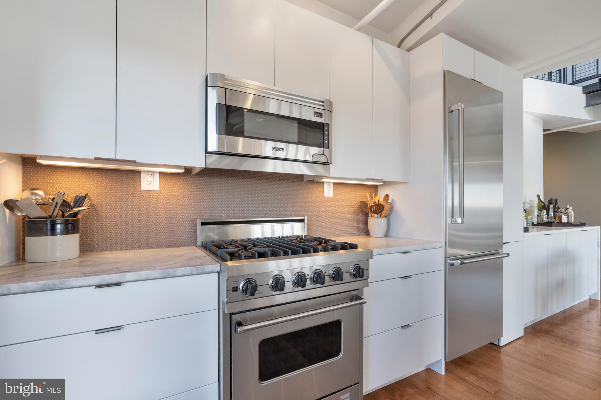 1700 Kalorama Road Northwest, Unit PH502 Washington, DC 20009 - Photo 27 of 50 a kitchen with stainless steel appliances granite countertop a sink stove and refrigerator