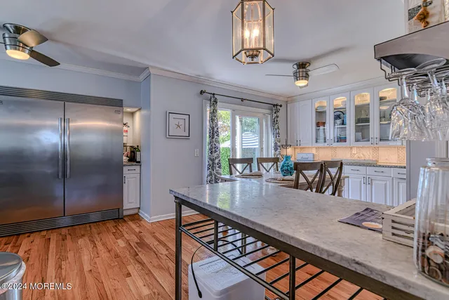 an open kitchen with granite countertop a stove and white cabinets