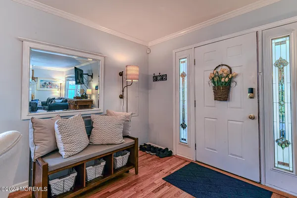 a dining room with furniture entryway and wooden floor